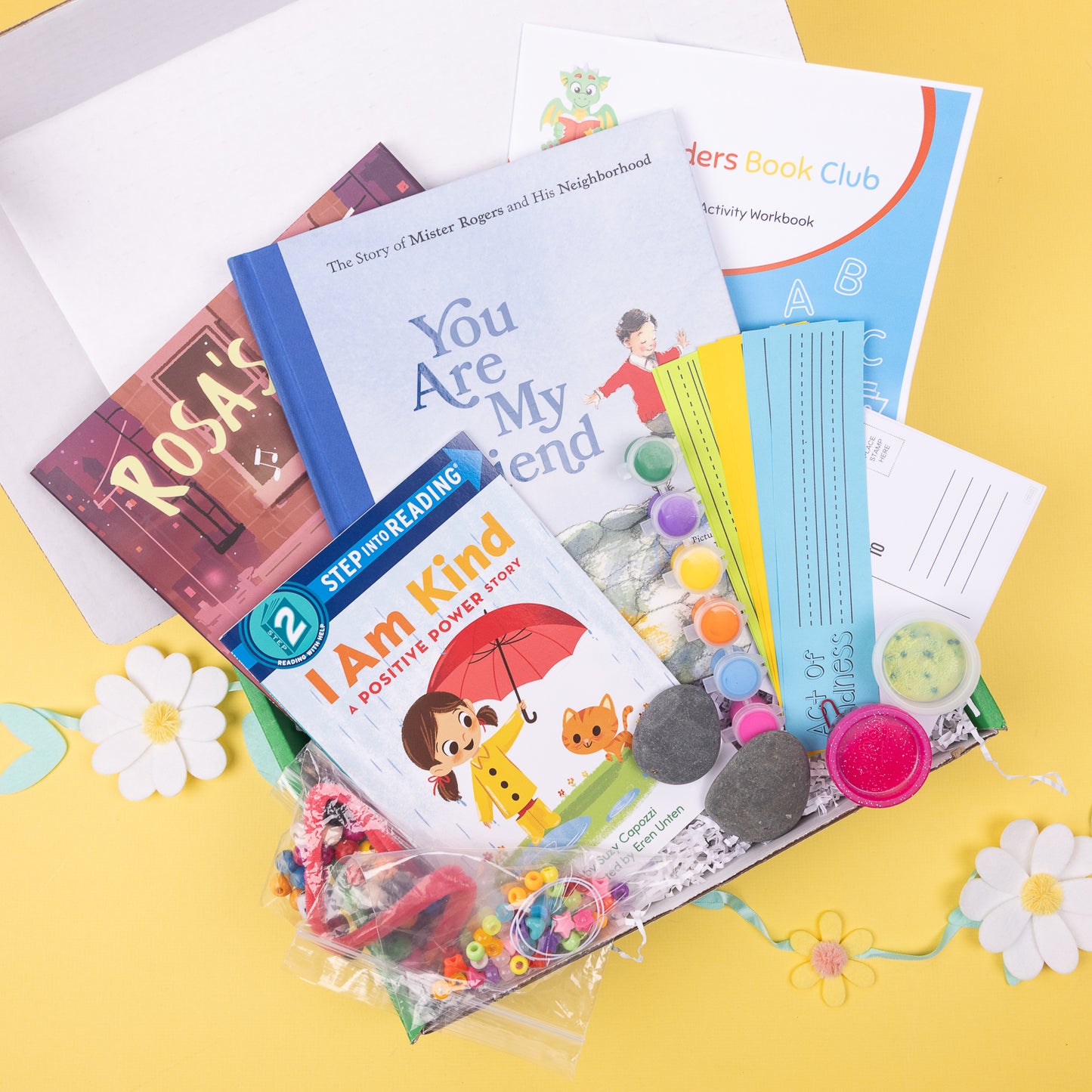 A book box containing various items for children, including books, crafts, and other educational materials, all geared towards promoting kindness and positive behavior.