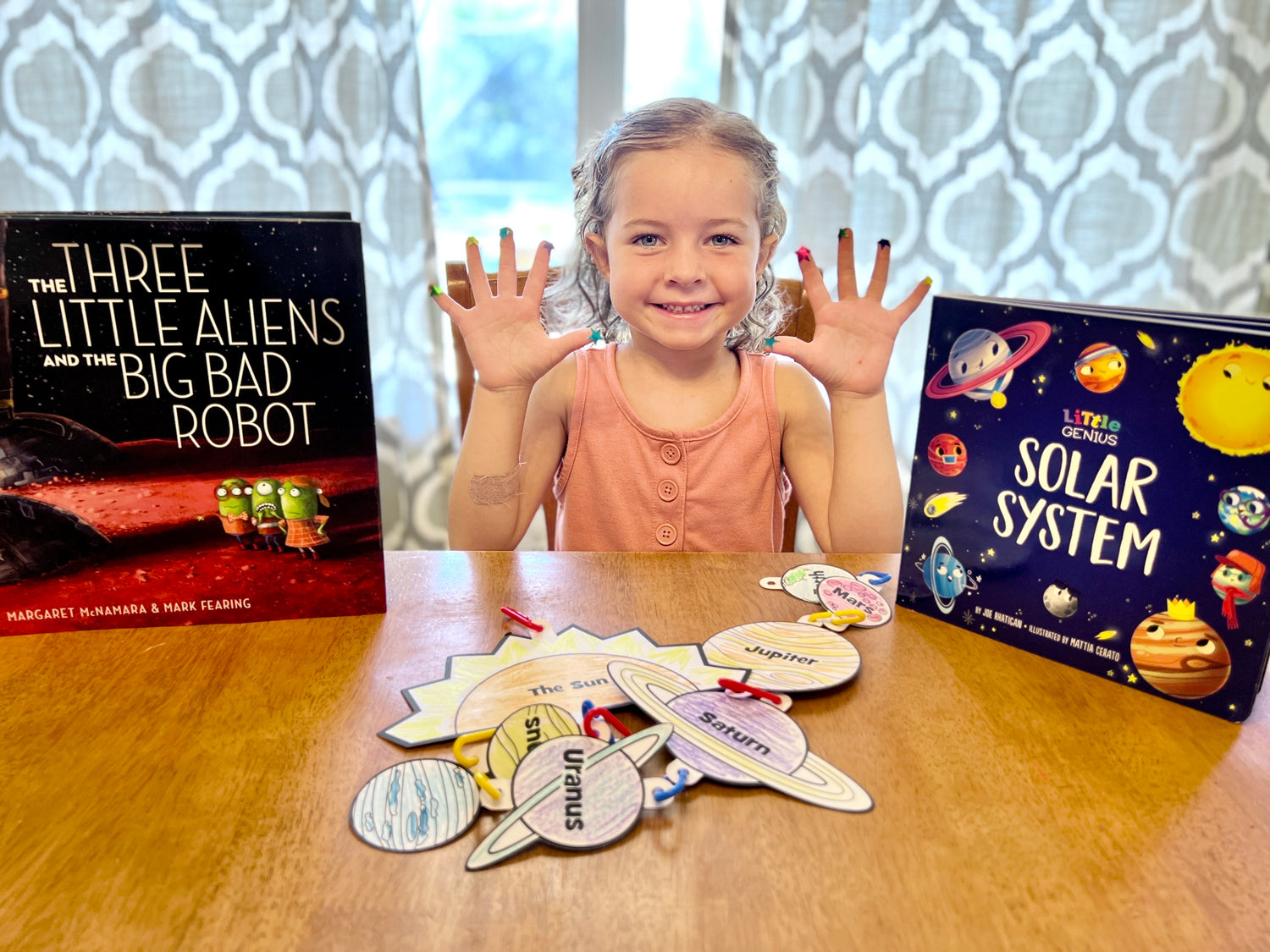 Young kid showing her little readers book club space themed box books and craft